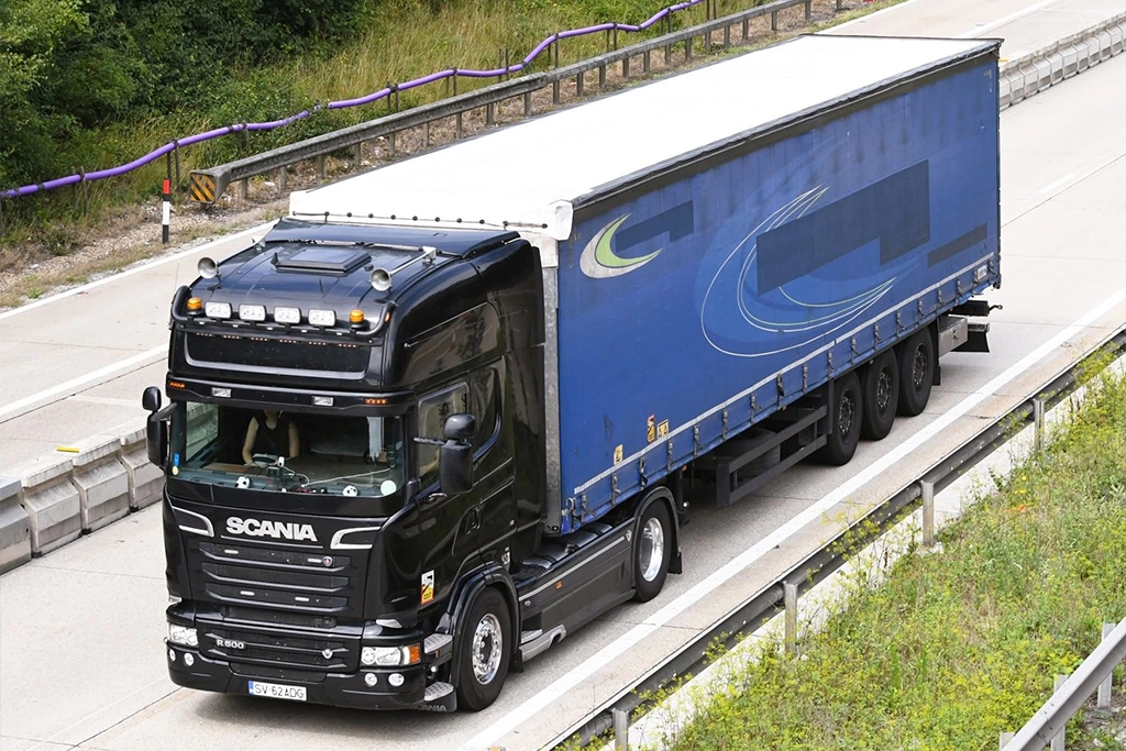 Ansamblu cap tractor Scania si semiremorca prelata fotografiat pe autostrada